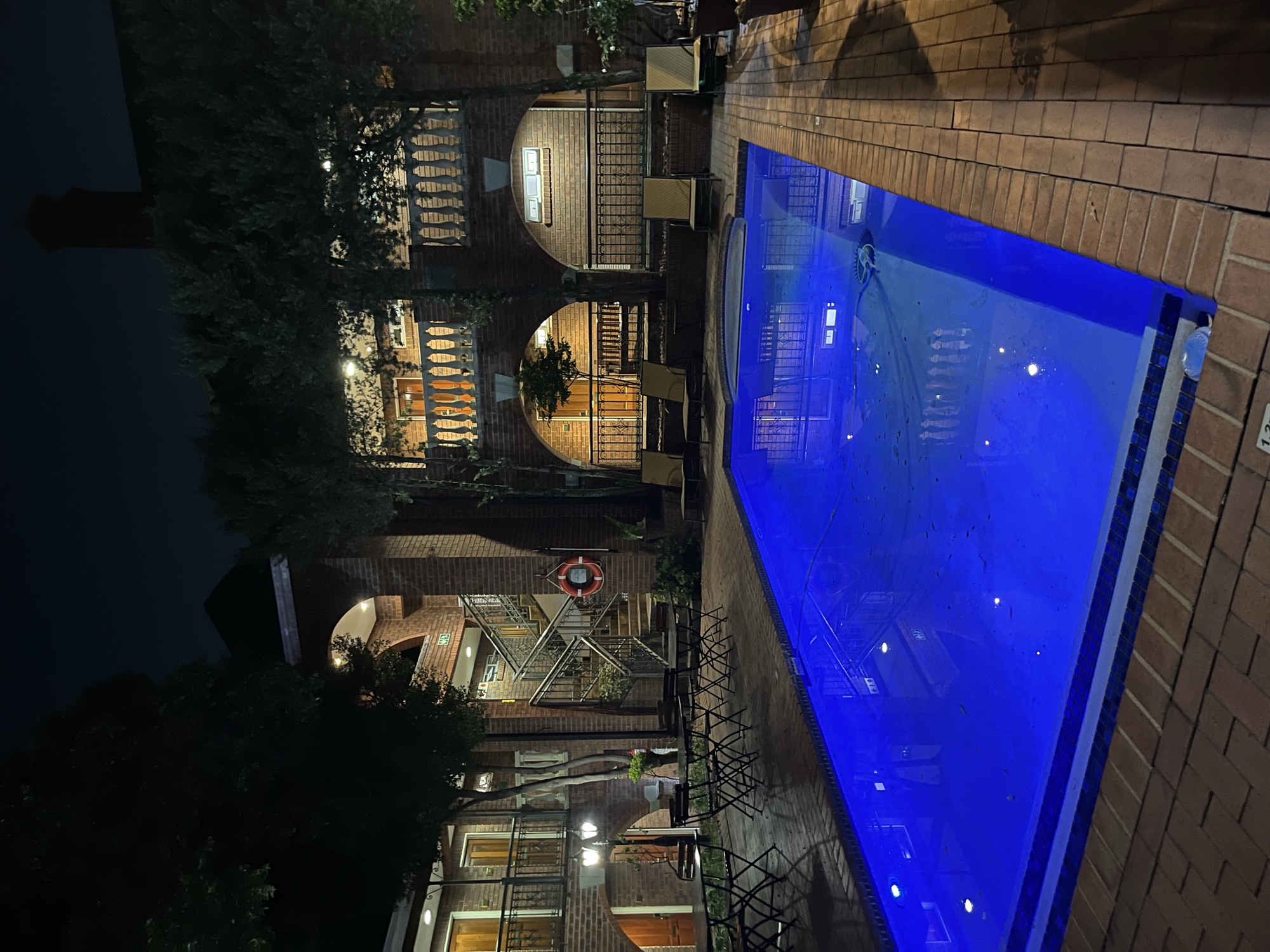 Illuminated pool at night in a courtyard