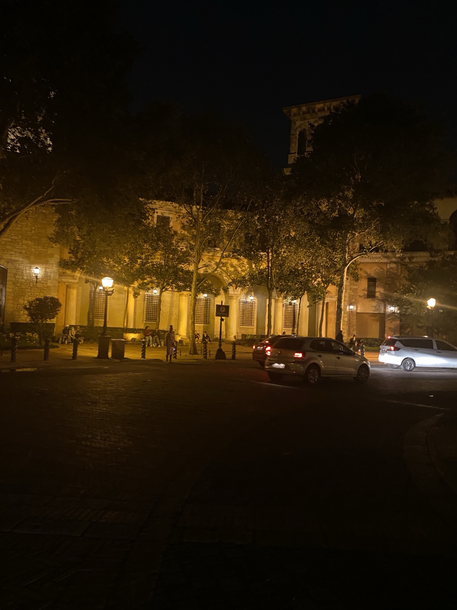 Historic building lit up on a quiet street at night